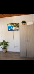 a room with a cabinet and two potted plants at Cosy Double Room in London Free Parking Private Bathroom Close to Transport in Belvedere