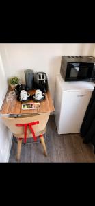 a small wooden table with a microwave on top of a counter at Cosy Double Room in London Free Parking Private Bathroom Close to Transport in Belvedere