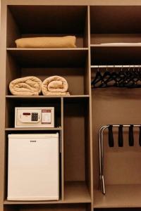 a walk in closet with a refrigerator and towels at Dall’Onder Grande Hotel Bento Gonçalves in Bento Gonçalves