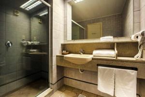 a bathroom with a sink and a mirror at Dall’Onder Grande Hotel Bento Gonçalves in Bento Gonçalves
