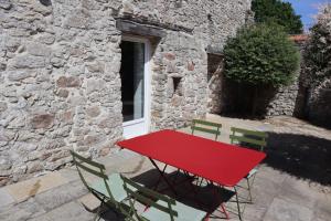 a red table and chairs in front of a building at Chambre, entrée indépendante, SDB privée in Cugand +2 photos