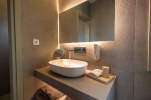 a bathroom with a bowl sink and a mirror at Onar Hotel Kimolos in Kimolos
