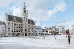 a large building with a clock tower on top of it at Spacious Apartment at Top Location Grote Markt in Sint-Niklaas
