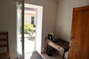 a room with a desk and a sliding glass door at Chambre, entrée indépendante, SDB privée in Cugand