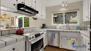 a large kitchen with white cabinets and appliances at Casa Rio Del Mar in Aptos