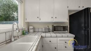 a kitchen with white cabinets and a black refrigerator at Casa Rio Del Mar in Aptos