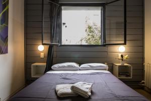 a bedroom with a bed with two towels on it at Aldea Hostel & Café in Córdoba +103 photos
