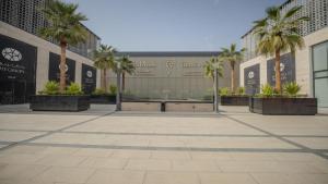 a courtyard with palm trees in front of a building at شقق فندقيه رسال in Ar Riyāḑ