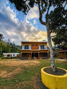 a house with a tree in front of it at Private Pool Villa Vagamon in Vagamon