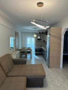 a living room and kitchen with a couch and a table at Paul House in Metamorfosi +1 photo