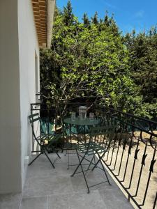 a green table and chairs on a balcony at Charmant studio proche du centre-ville in Orange
