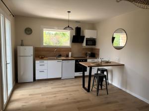a kitchen with white appliances and a wooden floor at Charmant studio proche du centre-ville in Orange