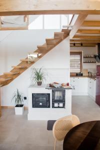 a kitchen with white walls and wooden stairs at Domek Nad Jeziorem 6 osobowy in Rożnów