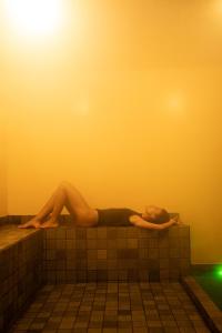 a woman laying on a wall in a bath tub at Pousada Nativa in Caraíva