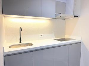 a white kitchen with a sink and a counter at ApartaSuite City Bog Usaquén in Bogotá