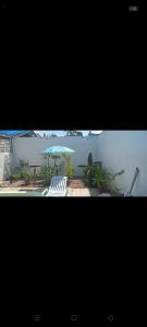 two chairs and an umbrella in front of a building at Casa moderna em Itapoá SC in Itapoa +2 photos