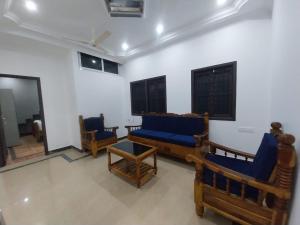 a living room with blue couches and chairs at De Lemo 3BHK Villa Homestay in Pondicherry