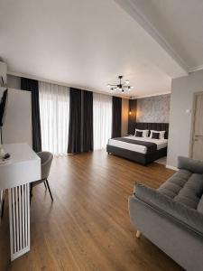 a large living room with a bed and a couch at Pensiunea Brici Junior in Cluj-Napoca