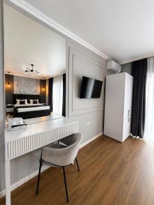 a white room with a desk and a bedroom at Pensiunea Brici Junior in Cluj-Napoca