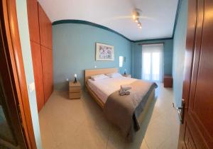 a bedroom with a bed and a blue wall at SONIA in Kallithea Halkidikis