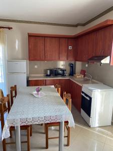 a kitchen with a table and chairs and a sink at SONIA in Kallithea Halkidikis