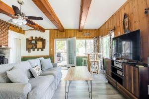 a living room with a couch and a tv at Waterfront Cottage, Fiery Sunsets in Charlotte