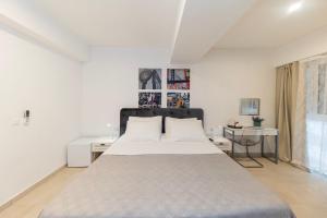 a white bedroom with a large bed and a window at CentRooms Kovac in Zadar