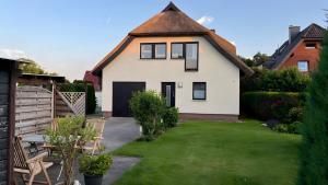 a white house with a thatched roof at Ferienwohnung Brunk in Altefähr +11 photos