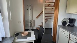 a kitchen with a spiral staircase in a room at Ferienwohnung Brunk in Altefähr