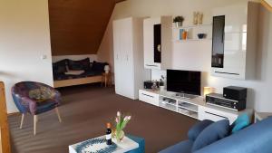 a living room with a blue couch and a tv at Ferienwohnung Brunk in Altefähr
