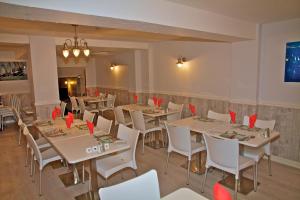 a dining room with tables and white chairs at The Leam Hotel in Weymouth