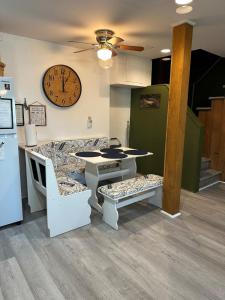 a kitchen with a table and a clock on the wall at Waterfront Cottage, Fiery Sunsets in Charlotte