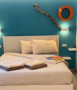 a bed with two towels and a blue wall at L4K3 Luxury Apartment - Lake View, Free Pool, Balcony, 50 m to Lake & Historic Center, 90 m2 in Pisogne +55 photos
