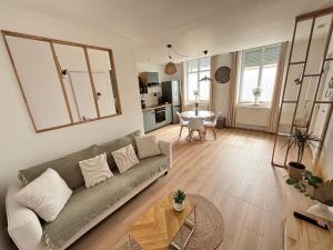 a living room with a couch and a table at Le Cocon des Remparts in Gravelines