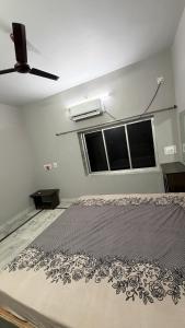 a bedroom with a bed and a ceiling fan at Cozy Cove 3BHK in Cuttack