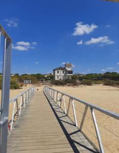 a wooden boardwalk leading to a house on the beach at Apartamentos Amy 5 in Huelva