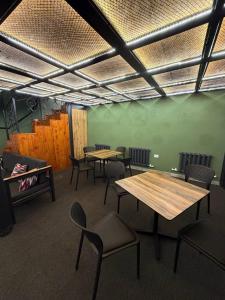 a room with tables and chairs and a green wall at The Loft Hostel in Tashkent