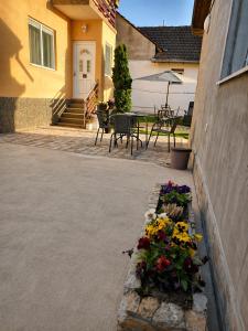 a patio with a bunch of flowers in a garden at Kuća Amazonija in Apatin