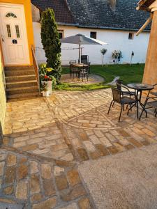 a patio with a table and chairs and an umbrella at Kuća Amazonija in Apatin