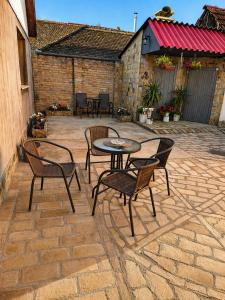 a patio with a table and chairs on a brick patio at Kuća Amazonija in Apatin