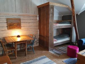 a room with a table and a bunk bed at Nygården B&B Hälsingegård in Harmånger