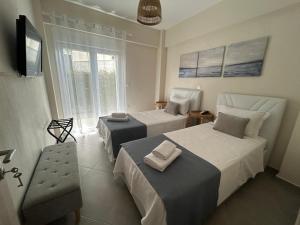 a bedroom with two beds and a tv and a window at Coral Nikiti Apartments I in Nikiti +25 photos
