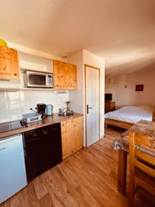 a kitchen with a sink and a bed in a room at studio le Bouquetin 304 in Chamrousse