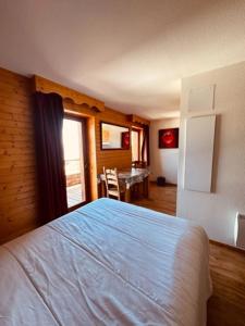 a bedroom with a bed and a table in it at studio le Bouquetin 304 in Chamrousse