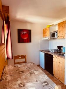 a small kitchen with a table and a microwave at studio le Bouquetin 304 in Chamrousse +4 photos