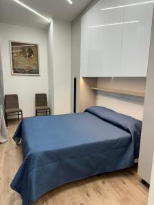 a bedroom with a blue bed and two chairs at Appartamento Svetlana Segrate in Segrate