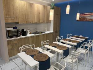 a room with tables and chairs and a kitchen at La Casa di Giorgio Panoramic Rooms in Naples