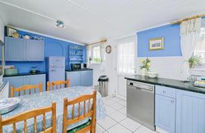 a kitchen with blue walls and a table and chairs at The Blue Dolphin with Panoramic Sea Views in Tythegston