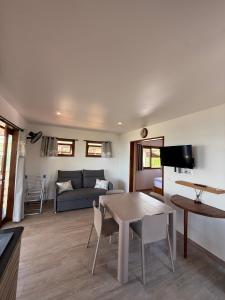 a living room with a table and a couch at Le Rainoa - Beach House in Taputapuapea