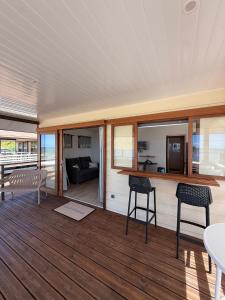 a living room with a table and chairs on a deck at Le Rainoa - Beach House in Taputapuapea